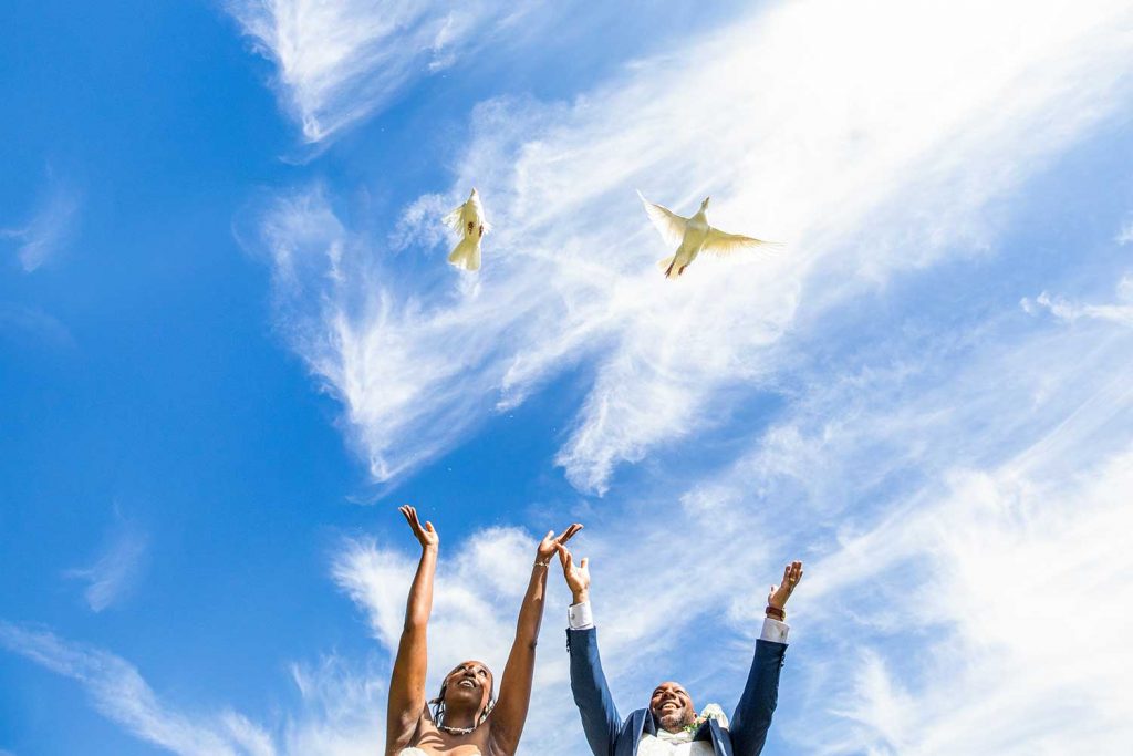 Bride and groom release doves into the sky at a wedding at Moor Hall