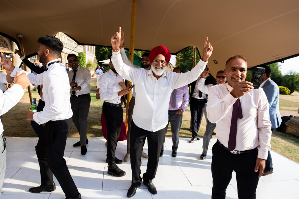 A group of men dancing on the dance floor at a wedding