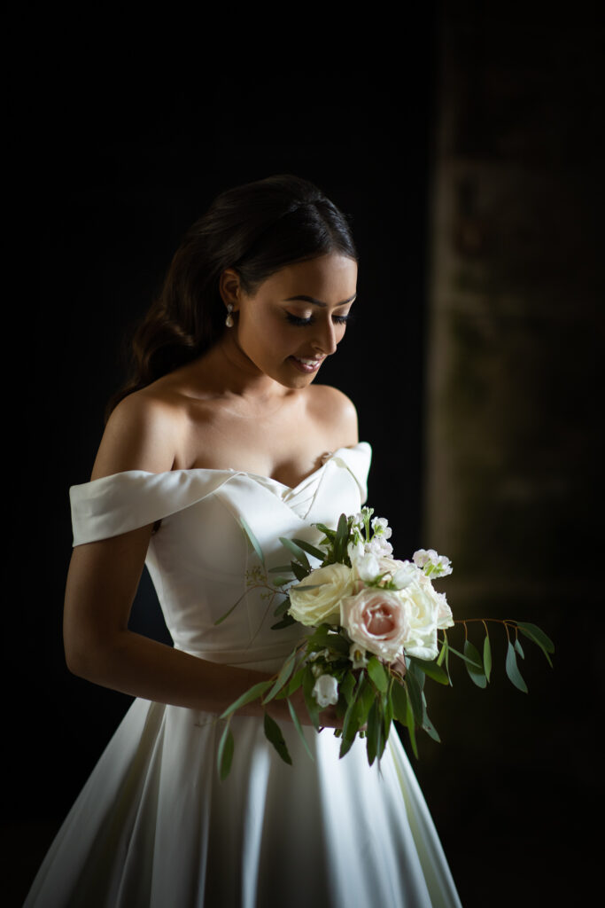 A beautiful bride looking down at her flowers and smiling