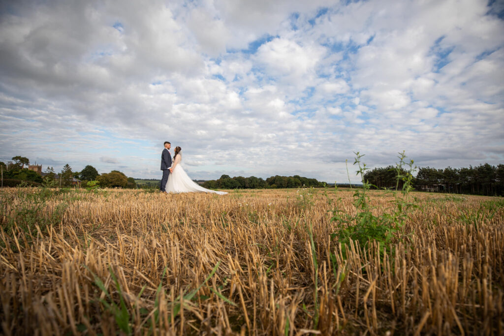 Bride and Groom standing in the fields at Curradine Barns wedding